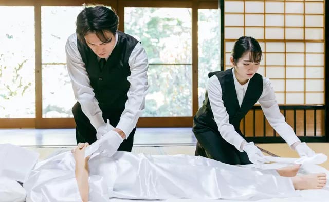 ご自宅で故人様にお身体の保全処理を施し、2人のスタッフで安置している様子。